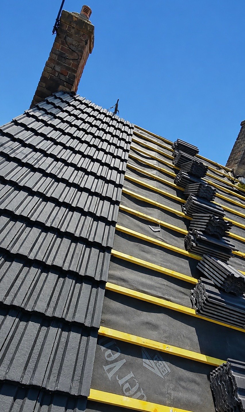 New grey roof tiles being laid