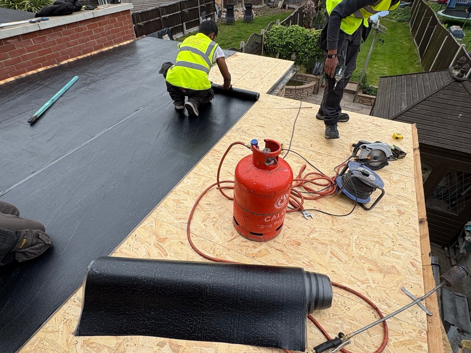 Torch-on felt being installed over new OSB decking